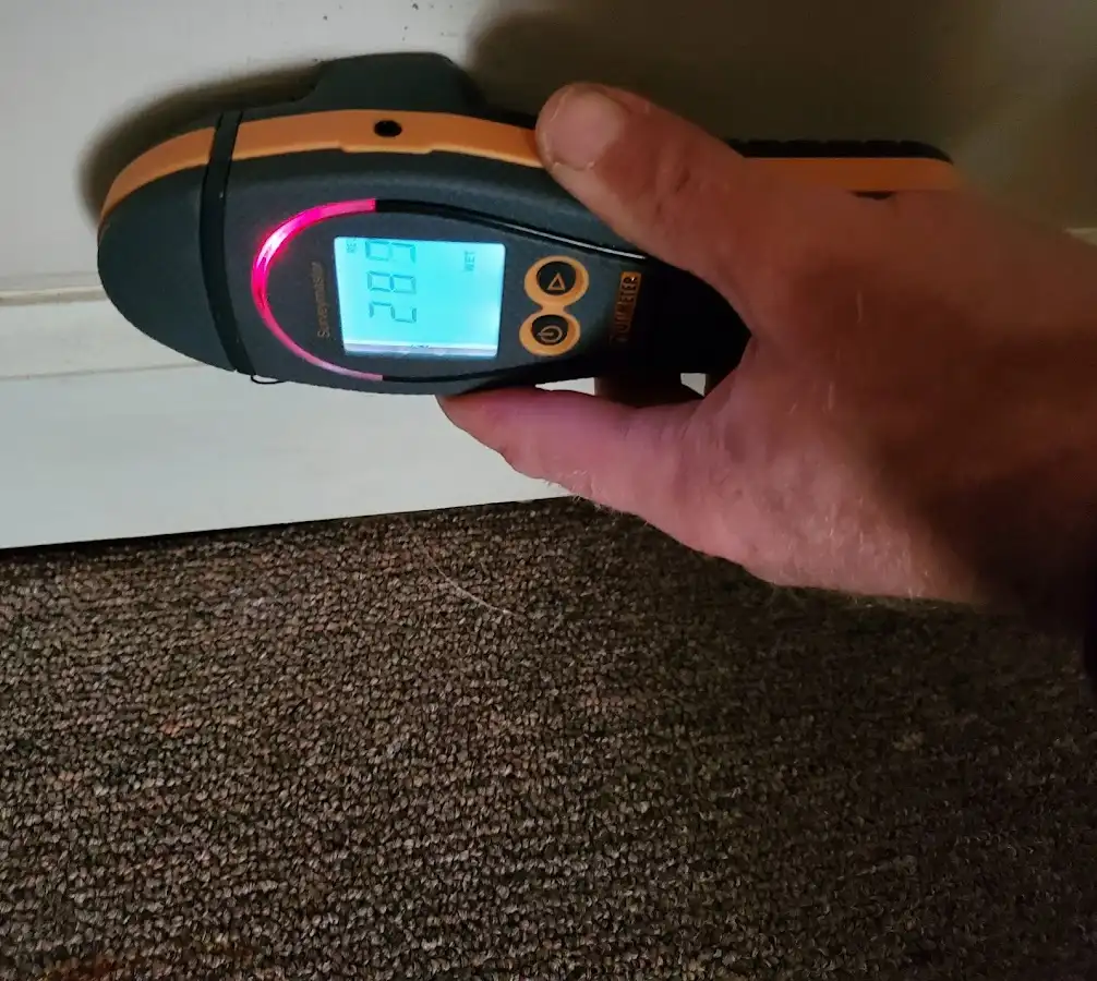 Moisture detection at baseboard during Storm Damage Restoration in Olive